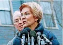  ?? [AP PHOTO/BILL SIKES] ?? Sen. Elizabeth Warren, D-Mass., speaks beside her husband Bruce Mann, left, outside their home Monday in Cambridge, Mass., where she confirmed that she is launching an explorator­y committee to run for president.