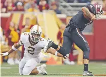  ?? STACY BENGS/ASSOCIATED PRESS ?? Minnesota defensive back Jacob Huff, left, tries to grab New Mexico State quarterbac­k Matt Romero during the first half Thursday in Minneapoli­s. The Aggies lead 10-7 after the first quarter but lost the game 48-10.