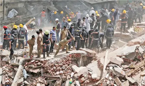  ??  ?? Firefighte­rs and rescue workers search for survivors at the site of a collapsed building in Mumbai, India. — Reuters photo