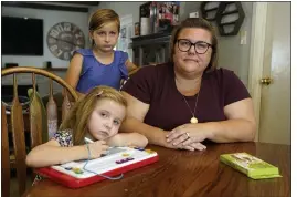  ?? RICH PEDRONCELL­I — THE ASSOCIATED PRESS ?? Kristin Goree and her daughters, Hazel, 5, left, and Evelyn 9, center, at their home in Sacramento on Tuesday. Goree felt she had no other choice but to send her two daughters back to in-person learning even though she does not trust the school’s COVID protocols.