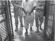  ?? JOHN MOORE/GETTY IMAGES ?? U.S. guards escort a detainee at the controvers­ial Guantanamo Bay detention centre.