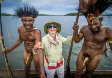  ??  ?? All smiles … the photo of a tourist holding the arms of two men in Western Province is one of David Kirkland’s favourites from the tens of thousands he has taken in PNG (above); the photo of a tribesman in front of a waterfall has been used in tourism campaigns (far left); Kirkland’s new book (left).