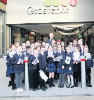  ??  ?? Ash Grove Academy pupils sing at the Grosvenor Centre