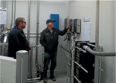  ??  ?? Farmer Bill Honeyfield pushing the power button of his new milking system for the first time as Think Water head technician James Cunniffe watches.