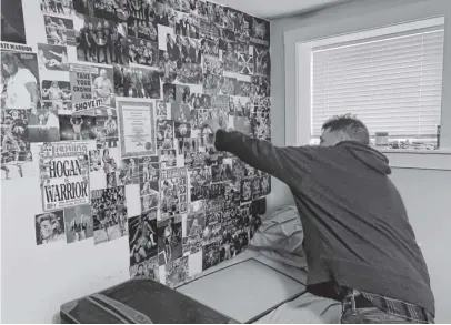  ?? CHRIS LAMBIE ■ THE CHRONICLE HERALD ?? Craig Boutilier points out his favourite wrestlers in a photo collage on the wall of his bedroom at a small options home in Kentville.