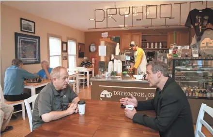  ?? MICHAEL SEARS / MILWAUKEE JOURNAL SENTINEL ?? Architect Paul Alt (right) and Bob Curry, who co-founded the healing space Dryhootch coffeehous­es, discuss what it takes to design and create a physical space that promotes healing of mind, spirit and body. They are at the Brady Street Dryhootch in...