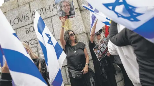  ?? AFP VIA GETTY IMAGES ?? Women hold portraits of missing and kidnapped Israeli girls and women during a demonstrat­ion outside the South African parliament in Cape Town on Friday to mark Internatio­nal Women’s Day and demand the release of female hostages taken by Hamas on Oct. 7.