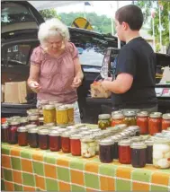  ??  ?? Sue Edwards and her grandson Aden from Rosedale near Rome provides a variety of items to shoppers, including honey.