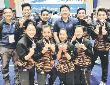  ?? — Photos courtesy of Dr WS Chen ?? Loh (second left) and Audrey (right, front row) and teammates with coach Tan Ching Fong (third right) and Internatio­nal Wushu Federation photograph­er Dr WS Chen (left) at the end of the World Taijiquan Championsh­ips in Burgas, Bulgaria on Tuesday.
