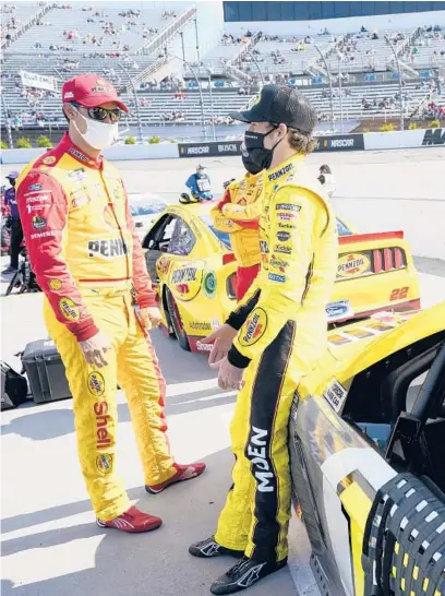  ?? STEVE HELBER/AP ?? Joey Logano, left, and Ryan Blaney talk on pit row at Martinsvil­le Speedway on April 11 in Martinsvil­le, Va.