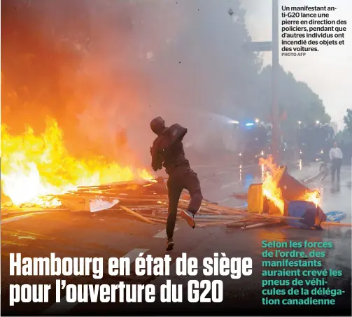  ?? PHOTO AFP ?? Un manifestan­t anti-g20 lance une pierre en direction des policiers, pendant que d’autres individus ont incendié des objets et des voitures.