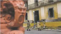  ?? SILVIA IZQUIERDO/ASSOCIATED PRESS ?? Firefighte­rs spray water Tuesday on the facade of the National Museum in Rio de Janeiro. Forensic investigat­ors waited for access into the museum’s interior to find what remains of the 20 million artifacts that made the museum one of the most important in Latin America.