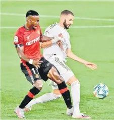  ?? — AFP photo ?? Real Mallorca’s forward Lago Junior (le ) challenges Real Madrid’s forward Karim Benzema during the Spanish League match at at the Alfredo di Stefano stadium in Valdebebas, on the outskirts of Madrid in this June 24 file photo.