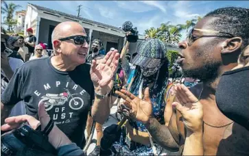  ?? Brian van der Brug Los Angeles Times ?? PALMDALE RESIDENT Josiah Mokelu, right, argues with a Huntington Beach man as several hundred people gathered near the pier. Police eventually declared an unlawful assembly and told attendees to leave.