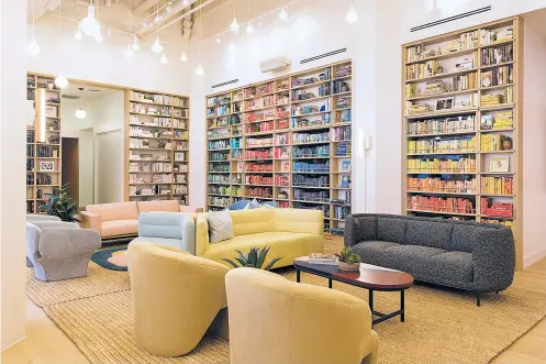  ?? TORY WILLIAMS, THE WING VIA WASHINGTON POST ?? The Wing, a chain of co-working spaces and social clubs, organizes books by spine color — an Instagram-friendly design.