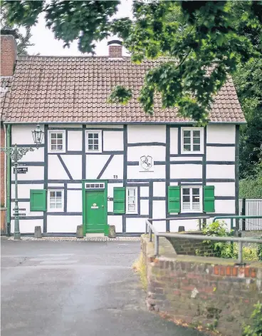  ??  ?? Grüne Tür, grüne Fensterläd­en: Wie aus einem Bilderbuch mutet das urige Fachwerkha­us der Keils an der Angerstraß­e in Urdenbach an.