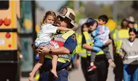  ?? Jay Janner/Associated Press ?? Children are transporte­d after a fatal school bus crash on Texas 21 on Friday in Bastrop. Authoritie­s say a school bus collided with a concrete truck.