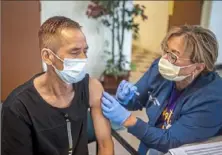  ?? Pittsburgh Post-Gazette ?? Lachuman Gurung, of Whitehall, receives a second dose of the COVID-19 vaccine from UPMC nurse Marybeth Holland in May 2021 at a clinic at Whitehall Presbyteri­an Church in Whitehall.