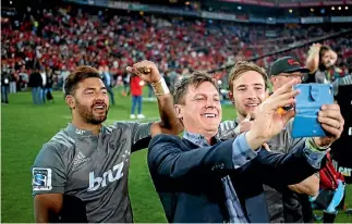  ?? REUTERS ?? Crusaders assistant coach Brad Mooar snaps a photo following the team’s 25-17 win over the Lions in the Super Rugby final in Johannesbu­rg on August 6. Richie Mo’unga, left, and Mitchell Hunt share the moment.