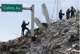  ?? (Carl Juste/Miami Herald/TNS) ?? PENNSYLVAN­IA SEARCH and Rescue team members comb through debris after the Champlain Tower South complex was demolished on Monday.