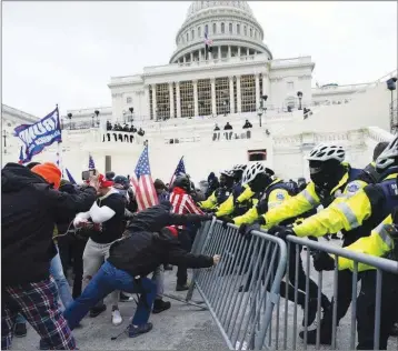  ?? AP ?? Protesters are seen Wednesday attempting to overtake Capitol police officers in front of the U.S. Capitol in Washington D.C. Moments later, protesters made their way to the front doors of the building, forcing their way in.