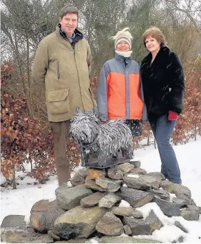  ??  ?? Tribute At the Westie sculpture are Ewen Cameron’s son Angus with wife Ollie (centre) and Kim Proven