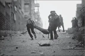  ?? Manu Brabo/associated Press ?? Opposition soldiers help a severely wounded colleague on Saturday after he had been shot by a Syrian army sniper in the Izaa section of Aleppo.