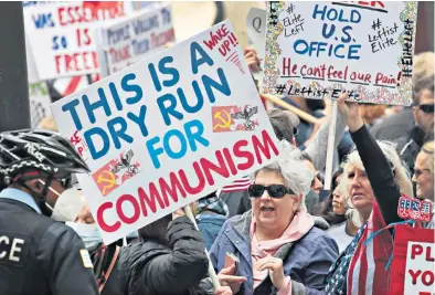  ??  ?? Anger unconfined Demonstrat­ors in Chicago protest against restrictio­ns imposed by JB Pritzker, the governor of Illinois. The state is on a “stay at home” order until May 30 in an effort to halt the virus’s spread.