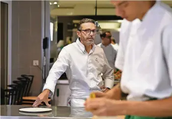  ??  ?? Starkoch Sébastien Bras schaut in der Küche seines Drei-Sterne-Restaurant­s „Le Suquet“einem seiner Mitarbeite­r über die Schulter. Er verzichtet freiwillig auf seine drei Sterne.