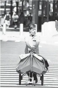  ?? LUIZ C. RIBEIRO/FOR NEW YORK DAILY NEWS ?? A U.S. Postal Service letter carrier is seen making his rounds in downtown Manhattan on Aug. 3.