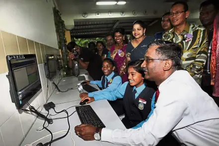  ??  ?? A pupil at SJK( T) Ladang Edinburgh showing Kamalanath­an how she uses the Frog VLE to learn.