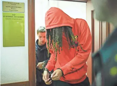  ?? ALEXANDER ZEMLIANICH­ENKO/AP ?? WNBA star and two-time Olympic gold medalist Brittney Griner leaves a courtroom after a hearing in Khimki, just outside Moscow, Russia, on Friday. Griner has been detained in Russia since February.