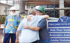  ?? ?? Paul Tonnessen hugs lead contractor Rob Baur at the Hale Pono Youth Shelter on Tuesday as Genesis Young cofounder of the Teran James Young Foundation looks on.