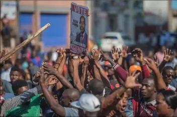  ??  ?? Opposition MDC party supporters hold a voting placard
Harare during clashes with police on Wednesday. AP PhoTo/MujAhId SAfodIen