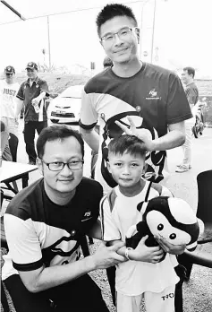  ??  ?? Wong (standing) and his deputy Andrew Ting (left) are seen after handing over the RS1 mascot to a boy during a meet-the-people session in Kampung Jeriah.