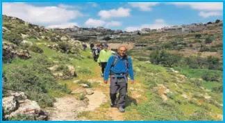  ??  ?? El guía del Camino de Abraham, Nidal Rishmawe, al frente del grupo de caminantes en las cercanías del pueblo cisjordano de Artas