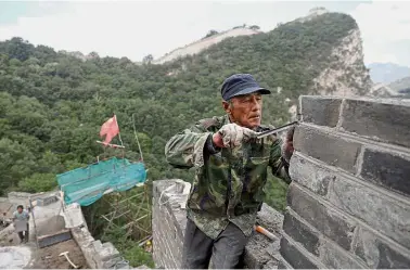  ?? — Reuters ?? A bricklayer working on the reconstruc­tion of the Jiankou section of the Great Wall, China.