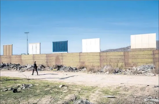  ?? Kent Nishimura Los Angeles Times ?? PROTOTYPES for President Trump’s new border wall loom above the current one from the Tijuana side. The prototypes are the focus of a tour arranged by an artist.