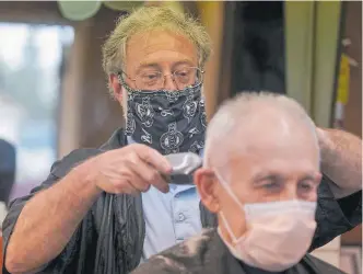  ??  ?? Owner Paul Furrer cuts the hair of Louis Rigano at Rick’s Barber Shop on Thursday in Waukesha, Wis.