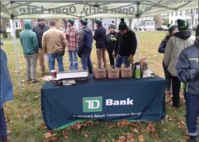  ?? MELISSA SCHUMAN - MEDIANEWS GROUP ?? The TD Bank volunteers keep warm as they get ready to plant trees with Capital Roots.