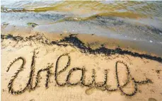  ?? FOTO: DPA ?? Das Wort Urlaub in Sand geschriebe­n: Resturlaub zu einem neuen Arbeitgebe­r mitnehmen? Ein Gesetz dafür gibt es schon.