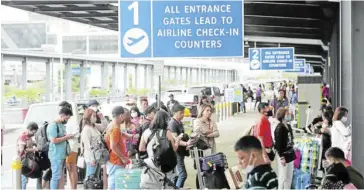  ?? ?? Passengers line up at the departure area of the Ninoy Aquino Internatio­nal Airport.