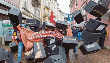  ?? EPA PIC ?? Participan­ts in a ‘No G20’ demonstrat­ion break through a wall of black cartons on a street in BadenBaden, Germany, on Saturday.