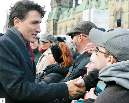  ??  ?? 1. Le premier ministre Justin Trudeau salue la foule lors de la cérémonie du jour du Souvenir au Monument commémorat­if de guerre national à Ottawa.
2. Le gouverneur général David Johnston dépose une couronne de fleurs.
3. Un vétéran embrasse son...