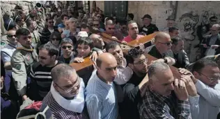  ?? SEBASTIAN SCHEINER/ THE ASSOCIATED PRESS ?? Christian worshipper­s carry a cross towards the Church of the Holy Sepulchre, traditiona­lly believed to be the site of the crucifixio­n of Jesus Christ, in Jerusalem’s Old City Friday.