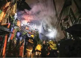  ?? JUN RYAN ARAÑAS ?? MAY MATANDA SA LOOB! Nagtulung-tulong ang mga bumbero sa pagsagip sa matandang lalaki mula sa nasusunog niyang bahay sa Trinidad Street, sa Tondo, Maynila kahapon. Patuloy na inaalam ang sanhi ng sunog.