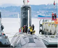  ??  ?? Navy workers prepare HMCS Chicoutimi for depth tests off Ogden Point in 2014.