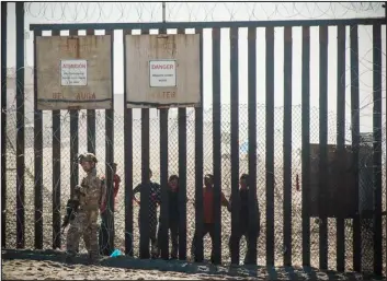  ?? ARIANA DREHSLER / AFP FILE PHOTO VIA GETTY IMAGES ?? A U. S. Border Patrol officer stands in front of the border fence that divides the US and Mexico at Friendship Park on Nov. 16, 2018 in San Diego.