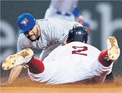  ?? CHARLES KRUPA THE ASSOCIATED PRESS ?? Blue Jays second baseman Devon Travis, left, tags out Boston's Xander Bogaerts as he tries to stretch a single to a double in the fourth inning. The Red Sox became the first club to win 100 games this season with a 1-0 decision.
