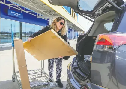  ?? JOHN MAHONEY ?? Debbie Grant loads boxes for a desk she ordered online into her car at Ikea in Saint-laurent on Wednesday. Grant had to purchase the desk in order to work from home. Ikea temporaril­y closed all its Canadian stores as of Wednesday but still sells products on Ikea.ca.